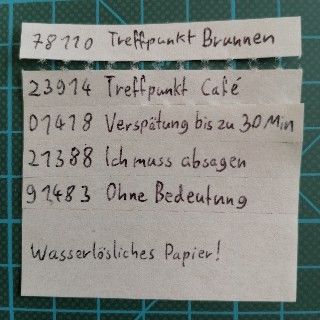 Der oberste Streifen, "Treffpunkt Brunnen", ist über die Perforation abgetrennt worden, und liegt unmittelbar über dem restlichen Zettel.