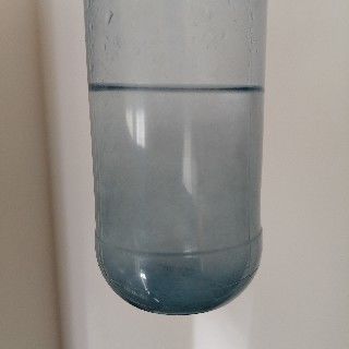 In der Kunststoffflasche ist nunmehr trübes Wasser, und die Streifen des Zettels sind nicht mehr erkennbar, da sie sich auf einzelne Fasern aufgelöst haben.